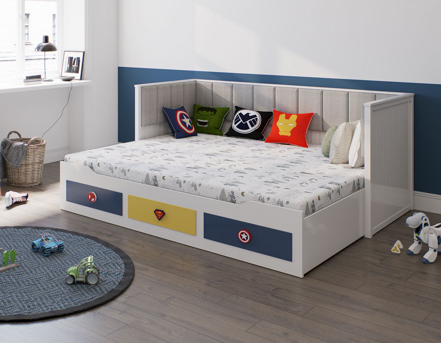 A modern white coloured trundle bed adorned with superhero-themed cushions, in a neatly arranged child's room with playful toys and a soft round rug.