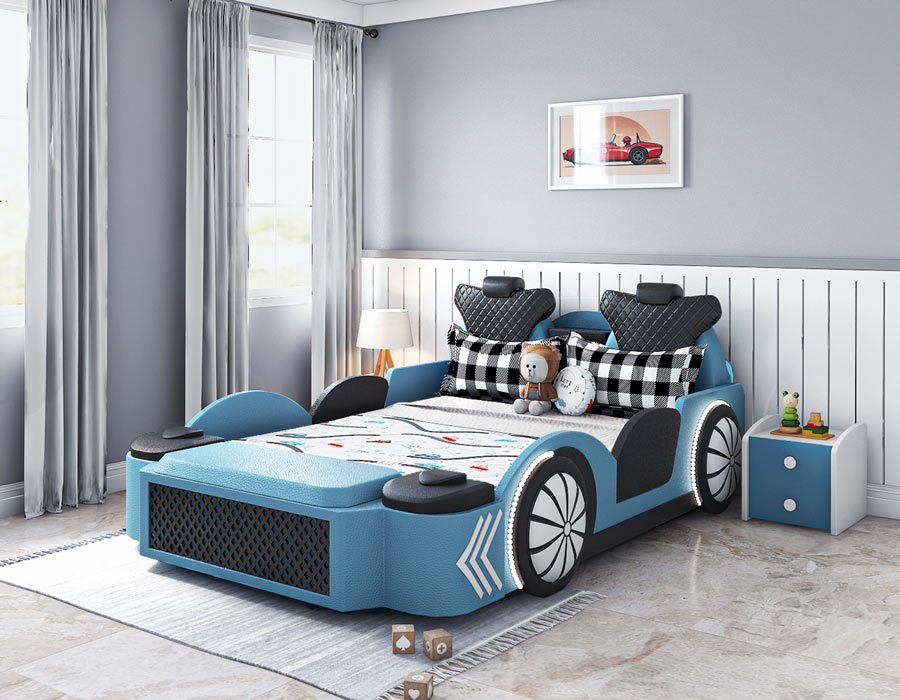 Stylish and fun children's bedroom featuring a blue car-shaped bed with realistic details like wheels and a front grille. The bed is decorated with colorful bedding and pillows, including a teddy bear. The room has blue walls, white wainscoting, and large windows with gray curtains. A bedside table with toys and books, a vintage wall clock, and car-themed wall art complete the playful and cozy atmosphere.