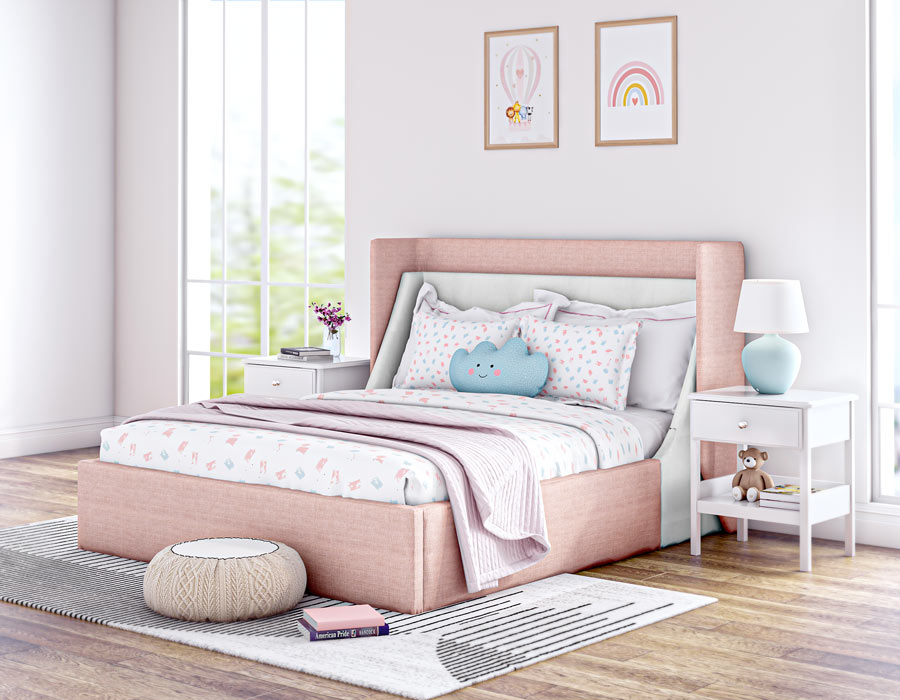 Bright and cozy children's bedroom featuring a pink-colored upholstered bed with a high headboard. The bed is adorned with playful pillows, including a polka dot pattern and a toy. The room has large windows letting in natural light, a white bedside table with decorative items, and wooden flooring. Wall art with positive messages adds a cheerful touch to the inviting space.